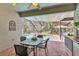 Screened patio with dining table overlooking pool and hot tub with outdoor kitchen at 8202 Pinewood Run Ct, Tampa, FL 33647
