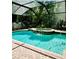 Clear turquoise swimming pool and hot tub with a screened enclosure and brick patio at 8202 Pinewood Run Ct, Tampa, FL 33647