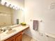 Bathroom featuring a sink, neutral tile flooring, and a large mirror with vanity lights at 8796 Christie Dr, Largo, FL 33771