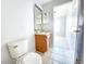 Bathroom with tile flooring, a single sink vanity, mirror, and toilet with neutral colored walls at 8796 Christie Dr, Largo, FL 33771