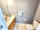 Cozy powder bathroom featuring gray walls, tile floors, and a wood vanity with a sink next to a toilet at 8796 Christie Dr, Largo, FL 33771