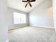Bright bedroom featuring a ceiling fan, neutral walls, and a large window allowing ample natural light at 8796 Christie Dr, Largo, FL 33771