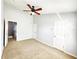 Spacious bedroom with neutral walls, carpet, a ceiling fan, and two closet doors at 8796 Christie Dr, Largo, FL 33771