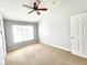 Large bedroom with ample space, a ceiling fan, neutral walls, carpet, and natural light from the window at 8796 Christie Dr, Largo, FL 33771