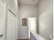 Upstairs hallway featuring a picture frame and closet doors along a neutral-colored wall at 8796 Christie Dr, Largo, FL 33771