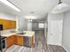 Open-concept kitchen features stainless steel appliances, wood cabinets, and view into the living area at 8796 Christie Dr, Largo, FL 33771