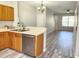 Kitchen with stainless steel dishwasher, wood cabinets, and breakfast bar looking into a spacious living area with modern flooring at 8796 Christie Dr, Largo, FL 33771