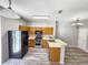 Well-lit kitchen featuring wood cabinets, modern stainless steel appliances, and a breakfast bar overlooking the adjacent dining area at 8796 Christie Dr, Largo, FL 33771