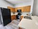 Galley kitchen with stainless steel appliances, light countertops and ample wooden cabinetry at 8796 Christie Dr, Largo, FL 33771