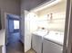 Laundry room with side by side washer and dryer and a wire rack for storage at 8796 Christie Dr, Largo, FL 33771