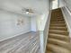 Open living area with modern flooring, staircase, ceiling fan, and plenty of space for comfortable seating and decor at 8796 Christie Dr, Largo, FL 33771
