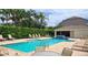 Inviting community pool area with lounge chairs, lush landscaping, and a covered outdoor space at 8796 Christie Dr, Largo, FL 33771
