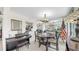 Bright dining area featuring a modern chandelier, adjacent piano, and charming window seat at 919 Seddon Cove Way # 919, Tampa, FL 33602