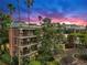 Multi-story building at dusk with balconies, surrounded by mature trees and an asphalt driveway at 919 Seddon Cove Way # 919, Tampa, FL 33602