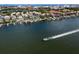 Aerial view of waterfront homes, docks, and a boat creating a beautiful wake on the water at 927 Anchorage Rd, Tampa, FL 33602