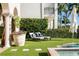 Backyard offers lawn seating with waterfront views, palm trees and lush tropical landscaping at 927 Anchorage Rd, Tampa, FL 33602