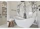 Bright bathroom featuring a freestanding tub, a stool with fresh towels, and an accent marble wall at 927 Anchorage Rd, Tampa, FL 33602