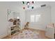 Bright bedroom features colorful light fixture, hardwood floors, dollhouse, and large windows at 927 Anchorage Rd, Tampa, FL 33602