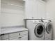 Laundry room with white cabinets, marble countertop, and a new Samsung washer and dryer set at 927 Anchorage Rd, Tampa, FL 33602
