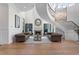 Cozy living room with a grand stone fireplace, two sofas, two wingback chairs, and a staircase at 927 Anchorage Rd, Tampa, FL 33602