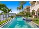 Beautiful backyard pool with spa overlooks the water with mature palm trees and lush landscaping at 927 Anchorage Rd, Tampa, FL 33602