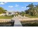 Waterfront home with a patio with chairs, manicured landscaping, and a private dock at 935 Eden Isle Ne Dr, St Petersburg, FL 33704