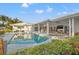 Inviting backyard with pool, spa, covered patio, and lush landscaping perfect for outdoor entertaining at 935 Eden Isle Ne Dr, St Petersburg, FL 33704