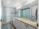 Bright bathroom with double sink vanity, large mirror, tiled floors, and plantation shutters at 935 Eden Isle Ne Dr, St Petersburg, FL 33704