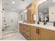 Bright bathroom features a double vanity, a modern shower with a glass door, and contemporary finishes at 935 Eden Isle Ne Dr, St Petersburg, FL 33704