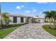 Beautiful single-story home with a long driveway and lush landscaping and a modern facade at 935 Eden Isle Ne Dr, St Petersburg, FL 33704