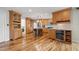 Spacious kitchen with stainless appliances, wine cooler, wood cabinets, island seating, and hardwood floors at 935 Eden Isle Ne Dr, St Petersburg, FL 33704