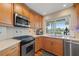 Kitchen with stainless steel appliances, wood cabinets, and a view overlooking the waterfront at 935 Eden Isle Ne Dr, St Petersburg, FL 33704