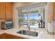 View from the kitchen window of a covered patio, outdoor grill, and inviting swimming pool at 935 Eden Isle Ne Dr, St Petersburg, FL 33704