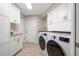 Spacious laundry room equipped with modern washer and dryer and ample storage cabinets at 935 Eden Isle Ne Dr, St Petersburg, FL 33704