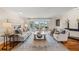 Elegant living room featuring hardwood floors, comfortable seating, and sliding glass doors to outdoor entertaining area at 935 Eden Isle Ne Dr, St Petersburg, FL 33704