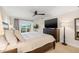 Relaxing main bedroom featuring a ceiling fan, TV and sliders to patio overlooking the water at 935 Eden Isle Ne Dr, St Petersburg, FL 33704