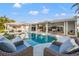 Inviting outdoor pool area featuring a spa, covered patio, and comfortable seating at 935 Eden Isle Ne Dr, St Petersburg, FL 33704