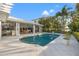 A beautiful pool and patio area are surrounded by lush tropical landscaping at 935 Eden Isle Ne Dr, St Petersburg, FL 33704