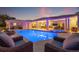 Backyard view featuring a luxurious pool, spa, covered patio, and comfortable seating areas at 935 Eden Isle Ne Dr, St Petersburg, FL 33704