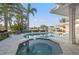 Beautiful pool and spa area with lush landscaping, waterfront views, and outdoor seating at 935 Eden Isle Ne Dr, St Petersburg, FL 33704