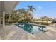 Sparkling pool and spa surrounded by tropical plants with a waterfront view creating a serene outdoor oasis at 935 Eden Isle Ne Dr, St Petersburg, FL 33704