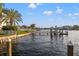 Relaxing waterfront view with a private dock, seating, and manicured landscaping at 935 Eden Isle Ne Dr, St Petersburg, FL 33704