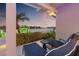 Inviting waterfront patio boasts comfortable lounge chairs with scenic views of the water at sunset at 935 Eden Isle Ne Dr, St Petersburg, FL 33704