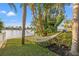 Serene waterfront backyard with a hammock between palm trees and lush landscaping at 935 Eden Isle Ne Dr, St Petersburg, FL 33704