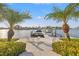Beautiful waterfront view showcasing a private dock with a boat lift, framed by lush palm trees at 935 Eden Isle Ne Dr, St Petersburg, FL 33704