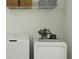 Bright laundry room featuring a white washer and dryer, storage baskets, and folded towels on a shelf at 9396 Minnow Ray Dr, Land O Lakes, FL 34638