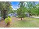 A view of the backyard that shows a large grassy area and mature trees offering lots of shade at 10130 Burton St, New Port Richey, FL 34654