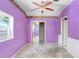 Bedroom featuring carpeting, closet and purple walls with floral wallpaper trim at 10130 Burton St, New Port Richey, FL 34654