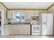 Bright eat-in kitchen with white appliances and neutral cabinets at 10130 Burton St, New Port Richey, FL 34654