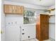 Laundry room with a utility sink, window and natural wood storage at 10130 Burton St, New Port Richey, FL 34654